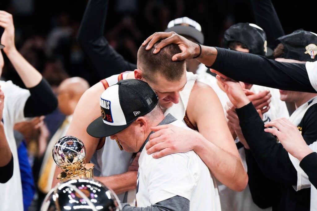 Nikola Jokic e Michael Malone se abraçam após conquista do título dos Nuggets. Foto: Icon sport